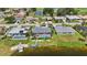 Aerial view of several homes featuring screen enclosed pools, manicured lawns, canals, and golf course views at 965 E Gondola Dr, Venice, FL 34293