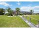 Expansive backyard featuring lush landscaping, a screened lanai, and a charming boardwalk path at 965 E Gondola Dr, Venice, FL 34293