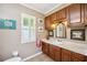 Cozy bathroom featuring wood cabinets, neutral countertops, decorative mirror, and a window with shutters at 965 E Gondola Dr, Venice, FL 34293