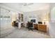 Bedroom features a mirrored closet, ceiling fan, and desk with shelving, offering an ideal space for work or relaxation at 965 E Gondola Dr, Venice, FL 34293