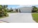 Charming home featuring a well-manicured lawn, a curved driveway, and a quaint fountain at 965 E Gondola Dr, Venice, FL 34293