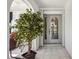 Close-up of the front door and entryway, framed by a potted plant, stone work and patio chairs at 965 E Gondola Dr, Venice, FL 34293