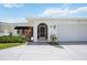 Inviting front entrance with an arched doorway, a well-maintained lawn, and beautiful landscaping at 965 E Gondola Dr, Venice, FL 34293