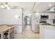 Open hallway leads to the kitchen with white cabinets and modern appliances, perfect for casual dining at 965 E Gondola Dr, Venice, FL 34293