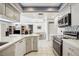 Bright open concept kitchen showcasing stainless steel appliances, white countertops, and breakfast bar seating at 965 E Gondola Dr, Venice, FL 34293