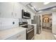 Close up of kitchen featuring stainless steel appliances, bright white countertops, and modern backsplash at 965 E Gondola Dr, Venice, FL 34293