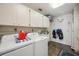 Bright laundry room with washer, dryer, sink, and ample cabinet space for storage at 965 E Gondola Dr, Venice, FL 34293
