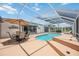 Large screened-in pool with an outdoor seating area, grill, and a chaise lounge chair at 965 E Gondola Dr, Venice, FL 34293