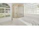 Bathroom with tub, shower, tile flooring, glass block window, and natural light at 11022 Pine Lilly Pl, Lakewood Ranch, FL 34202