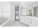 All-white bathroom includes double sinks, marble floors, and separate shower/tub at 11022 Pine Lilly Pl, Lakewood Ranch, FL 34202