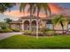 Charming single-story home with arched entryways, lush landscaping, and a well-manicured lawn at 11022 Pine Lilly Pl, Lakewood Ranch, FL 34202