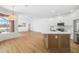 Open-concept kitchen features a center island, stainless steel appliances, and wood-look flooring at 11022 Pine Lilly Pl, Lakewood Ranch, FL 34202