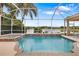 Screened-in pool and spa with a view of a tranquil lake surrounded by lush landscaping at 11022 Pine Lilly Pl, Lakewood Ranch, FL 34202