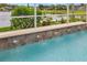 A refreshing swimming pool with serene lake view and lush landscaping at 11022 Pine Lilly Pl, Lakewood Ranch, FL 34202