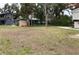 An overgrown backyard shows an expanse of grass and a storage shed adjacent to the home at 104 22Nd Street E Ct, Bradenton, FL 34208