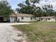 Residential property with a gravel driveway, open lawn, and adjacent house structures at 104 22Nd Street E Ct, Bradenton, FL 34208