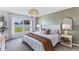 Stylish main bedroom with textured accent wall, large window and modern light fixture at 10824 Gentle Current Way, Parrish, FL 34219