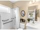 Bright bathroom features a stand-up shower with grab bars, a vanity, and a framed mirror for added convenience at 11794 Forest Park Cir, Bradenton, FL 34211