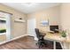 Bright home office with wood floors, a modern desk, and a window with natural light at 11794 Forest Park Cir, Bradenton, FL 34211