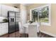 Eat-in kitchen showcasing stainless steel refrigerator, white cabinets, and sun-filled breakfast nook overlooking the backyard at 11794 Forest Park Cir, Bradenton, FL 34211