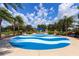 Community splash pad with a blue and white wave design, palm trees, and shade structures at 11794 Forest Park Cir, Bradenton, FL 34211