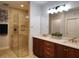 Well-lit bathroom with a walk-in shower, double vanity with granite counter tops, and modern fixtures at 1241 Riverscape St # B, Bradenton, FL 34208