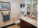 Cozy bathroom featuring granite counters, wood cabinets, and decorative nautical decor at 1241 Riverscape St # B, Bradenton, FL 34208