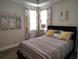Bedroom with a striped bed, accent pillows, matching curtains, and beach-themed decor at 1241 Riverscape St # B, Bradenton, FL 34208