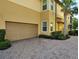 Spacious garage with a brick paver driveway and lush landscaping with a palm tree at 1241 Riverscape St # B, Bradenton, FL 34208