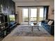 Modern living room with gray sofa, glass top table and large sliding doors to screened lanai with lake view at 1241 Riverscape St # B, Bradenton, FL 34208