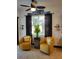 Comfortable sitting area with stylish chairs, ceiling fan, and view of the lush landscaping outside at 1241 Riverscape St # B, Bradenton, FL 34208