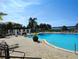 Stunning pool area with a pergola, lounge chairs, and palm trees overlooking the water at 1241 Riverscape St # B, Bradenton, FL 34208