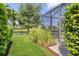 The meticulously landscaped backyard provides a serene escape with lush greenery and a glimpse of the lanai at 12908 Crystal Clear Pl, Bradenton, FL 34211