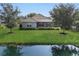 A lush green backyard featuring a pristine lawn and a tranquil pond, perfect for relaxation and outdoor enjoyment at 12908 Crystal Clear Pl, Bradenton, FL 34211