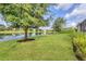 The well-maintained backyard features a tranquil pond, mature trees, and manicured lawn at 12908 Crystal Clear Pl, Bradenton, FL 34211