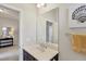 This is a view of the bathroom with a white countertop, dark brown vanity, and art pieces at 12908 Crystal Clear Pl, Bradenton, FL 34211