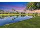 Scenic view of a serene pond reflecting the surrounding trees, homes, and colorful sky at 12908 Crystal Clear Pl, Bradenton, FL 34211