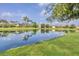 Picturesque view of the pond reflecting nearby homes and palm trees, enhancing the community's serene ambiance at 12908 Crystal Clear Pl, Bradenton, FL 34211