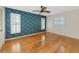 Bedroom with hardwood floors and floral wallpaper accent wall and white shutters at 1312 73Rd Nw St, Bradenton, FL 34209
