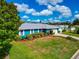 Bright blue single-story house with white trim, manicured lawn, and lush landscaping on a sunny day at 1312 73Rd Nw St, Bradenton, FL 34209