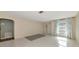 A well-lit living room with light-colored walls, tiled floors, curtains, and an arched doorway at 1312 73Rd Nw St, Bradenton, FL 34209