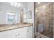 Updated bathroom showcasing granite countertop, tiled shower, and neutral colors at 17118 Vardon Ter # 404, Bradenton, FL 34211