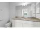 Well-lit bathroom featuring white cabinets, granite counters, and a large mirror at 17118 Vardon Ter # 404, Bradenton, FL 34211