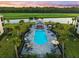 Aerial view of a beautiful outdoor pool with lounge chairs, umbrellas, and a covered seating area overlooking the golf course at 17118 Vardon Ter # 404, Bradenton, FL 34211