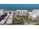 A fantastic aerial view of the property and buildings that are beachfront and near a tennis court at 1800 Benjamin Franklin Dr # B1009, Sarasota, FL 34236