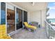 Balcony with a yellow chaise lounge and chairs offers stunning views of the beach and ocean at 1800 Benjamin Franklin Dr # B1009, Sarasota, FL 34236