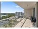 Spacious balcony with glass railings offers expansive views of the inter coastal waterway and nearby tennis courts at 1800 Benjamin Franklin Dr # B1009, Sarasota, FL 34236