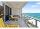 Balcony with outdoor seating showcases breathtaking views of the ocean and sandy beach on a clear day at 1800 Benjamin Franklin Dr # B1009, Sarasota, FL 34236