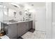 Bathroom with marble floors, dual sinks, modern cabinets, and mirrored walls, offering a sleek and functional design at 1800 Benjamin Franklin Dr # B1009, Sarasota, FL 34236