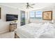 Bedroom featuring a wall-mounted television, ceiling fan, dresser, and great ocean views at 1800 Benjamin Franklin Dr # B1009, Sarasota, FL 34236